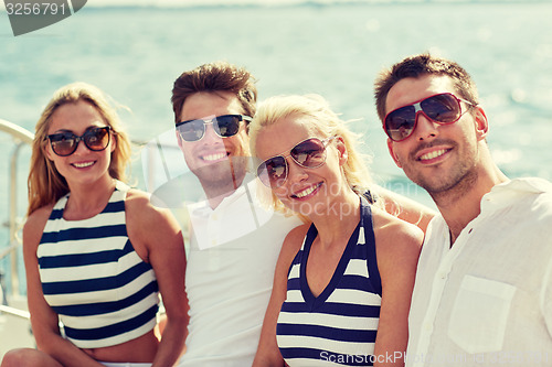 Image of smiling friends sitting on yacht deck