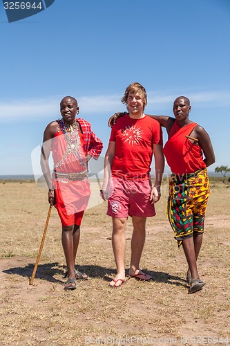 Image of MASAI MARA,KENYA, AFRICA- FEB 12 Masai men in traditional clothes and European tourists