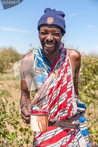 Image of Masai Mara, Kenya, Africa - February 12, 2010  shaman with a cup of cow blood in traditional clothes