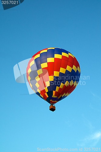 Image of hot air balloon of primary colors flying in sky