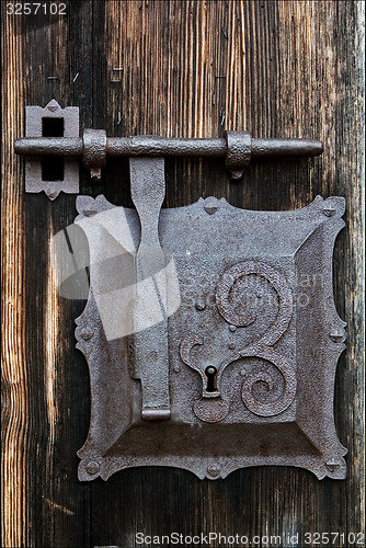 Image of metal lock screw and wood
