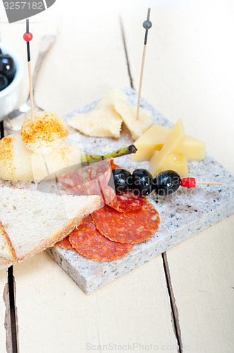 Image of mix cold cut on a stone with fresh pears