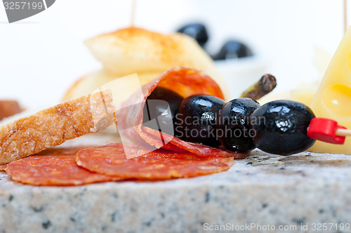 Image of mix cold cut on a stone with fresh pears