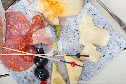 Image of mix cold cut on a stone with fresh pears