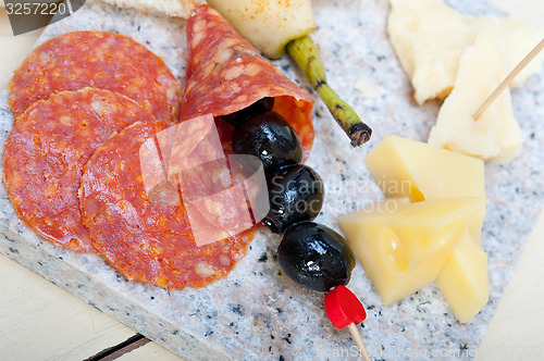Image of mix cold cut on a stone with fresh pears
