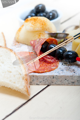 Image of mix cold cut on a stone with fresh pears