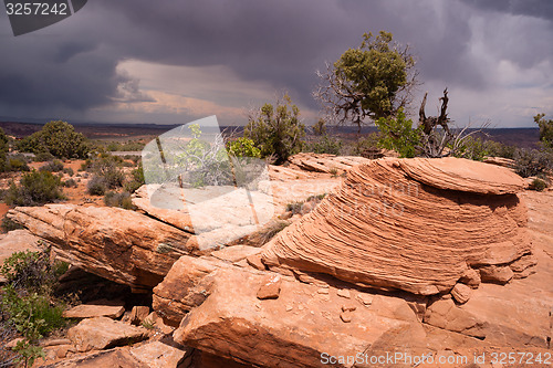Image of Rain Clouds Gather Over Rock Formations Utah Juniper Trees
