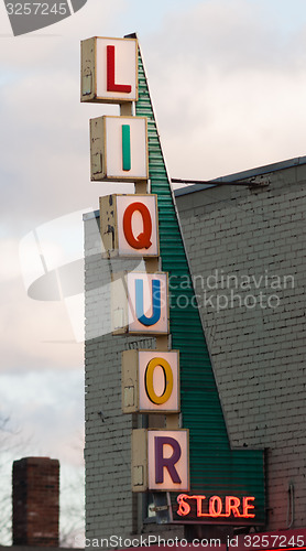 Image of Vertical Liquor Store Sign Brick Wall Outside Advetisement