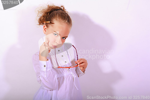 Image of Blond girl with ear piece in the mouth