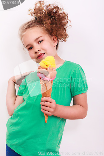 Image of Young blond wavy girl with ice-cream cone in the hand