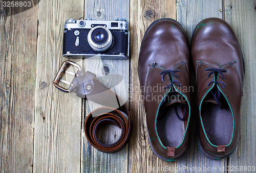 Image of sturdy boots, leather belt, and rangefinder camera