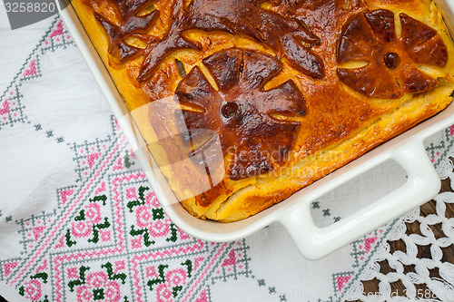 Image of cabbage pie on the embroidered cloth. Russian cuisine