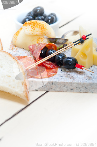 Image of mix cold cut on a stone with fresh pears