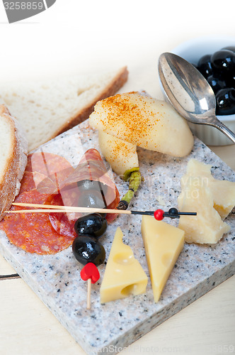 Image of mix cold cut on a stone with fresh pears