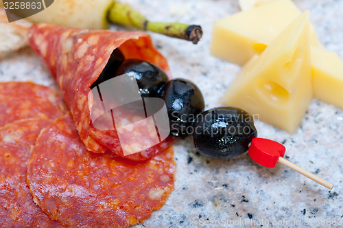 Image of mix cold cut on a stone with fresh pears