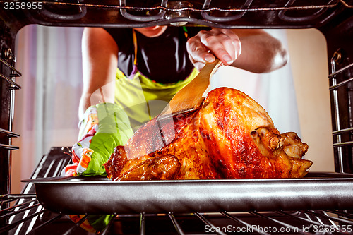 Image of Cooking chicken in the oven at home.