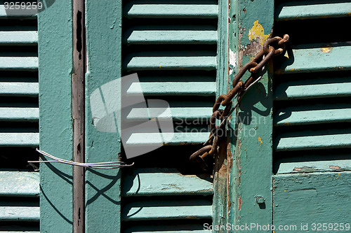Image of venetian blind and a rusty chain in la boca 