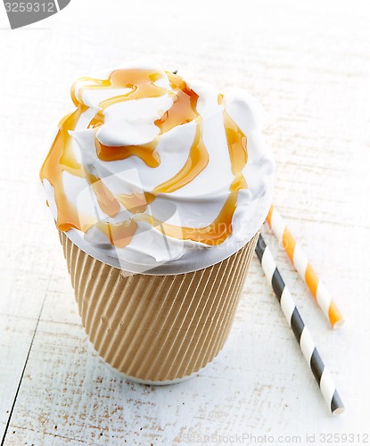 Image of caramel latte in paper take away coffee cup