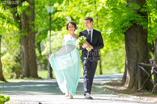 Image of Wedding couple walking in park.