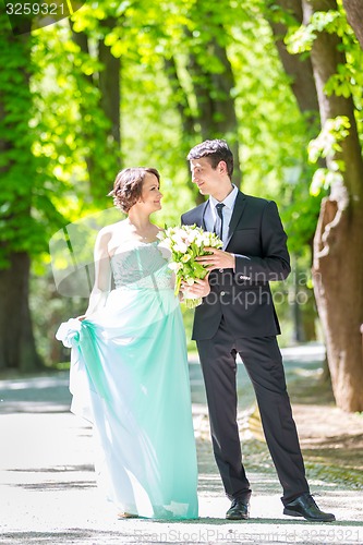 Image of Wedding couple walking in park.