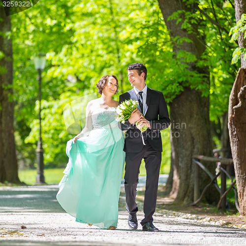 Image of Wedding couple walking in park.