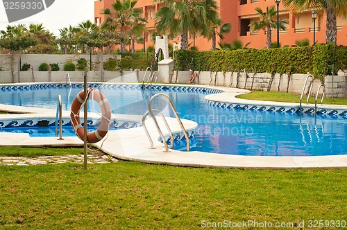 Image of Blue swimming pool and orange lifebelt