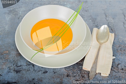 Image of Pumpkin cream soup with spoon and napkin