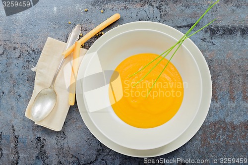 Image of Delicious healthy pumpkin soup, spoon and napkin