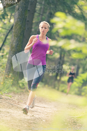Image of Pretty young girl runner in the forest. 