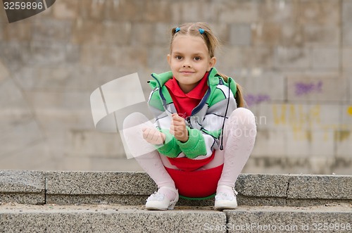 Image of Six-year girl sits on the granite steps