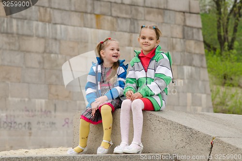 Image of Two girls sit on a granite ramp