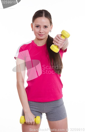 Image of Sportswoman raised her left arm with a dumbbell