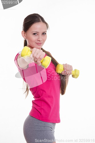 Image of Beautiful athlete holding a dumbbell at arm\'s length