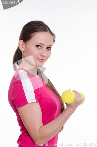Image of Sportswoman with dumbbells inflates his right hand