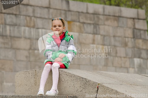 Image of Girl sitting a granite embankment on ramp