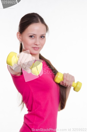 Image of Sportswoman with two dumbbells in the hands of