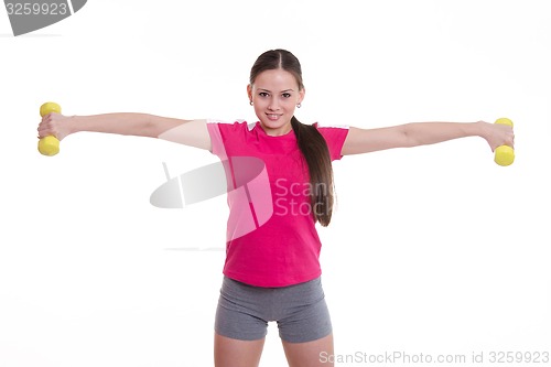 Image of Sportswoman stretched both arms with dumbbells