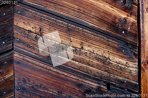 Image of Very old weather beaten door in brownish colours.