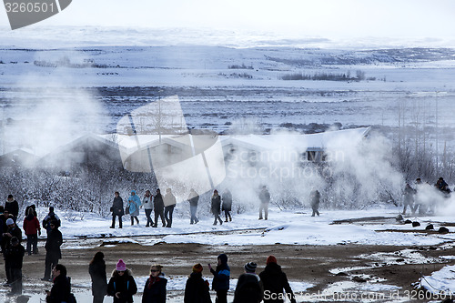 Image of Visitors watching the eruption of a geyser in Iceland