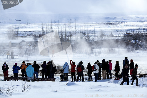 Image of Visitors watching the eruption of a geyser in Iceland