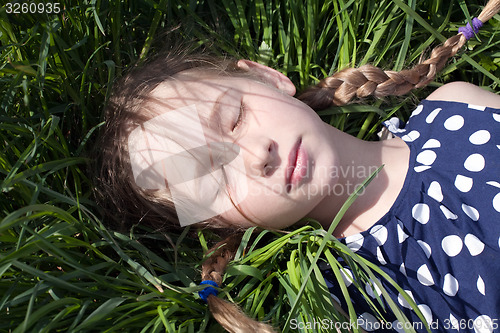 Image of young girl sleeping on green grass