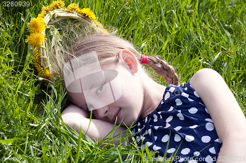 Image of young girl lying on green grass