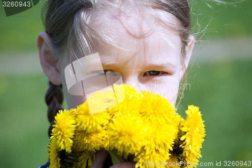 Image of girl\'s face with yellow dandelions