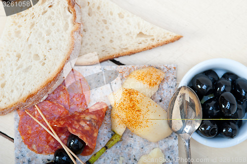 Image of mix cold cut on a stone with fresh pears