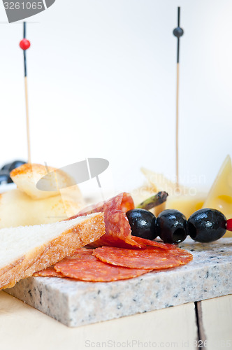 Image of mix cold cut on a stone with fresh pears