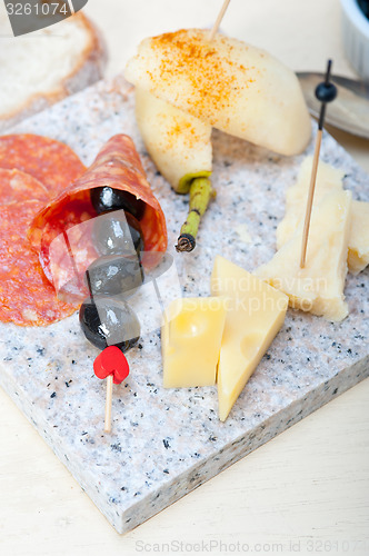 Image of mix cold cut on a stone with fresh pears