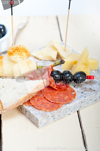 Image of mix cold cut on a stone with fresh pears