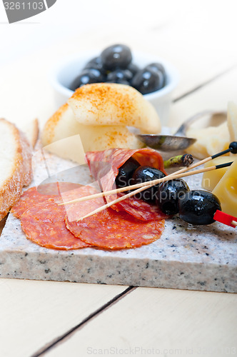 Image of mix cold cut on a stone with fresh pears