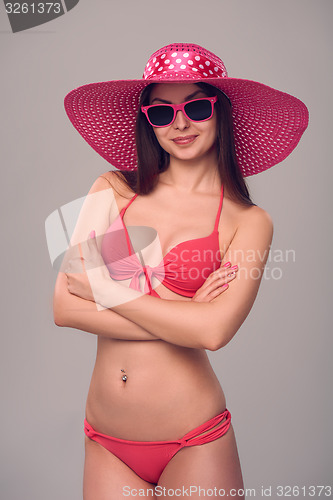 Image of Woman in pink swimsuit and hat