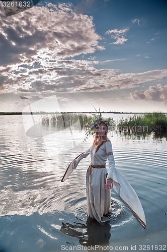 Image of Beautiful woman with flower wreath in water